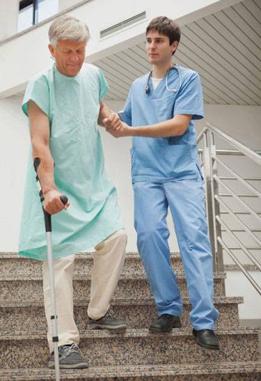 врач помогает пациентку спускаться по лестнице