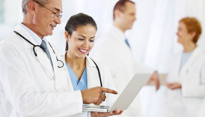 Two doctors looking at the laptop.